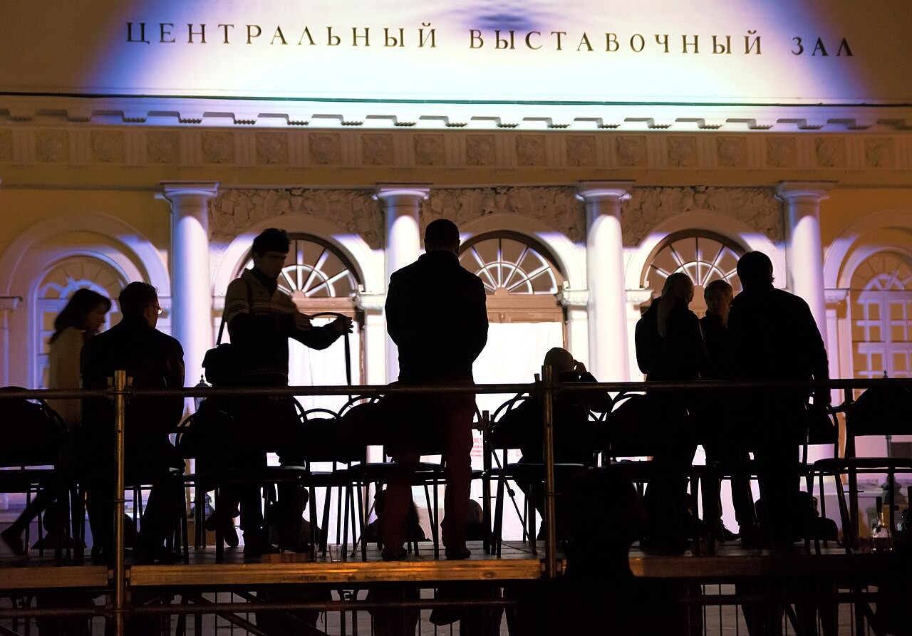 Architectural light projection illuminates the facade of the Moscow Manege at night.